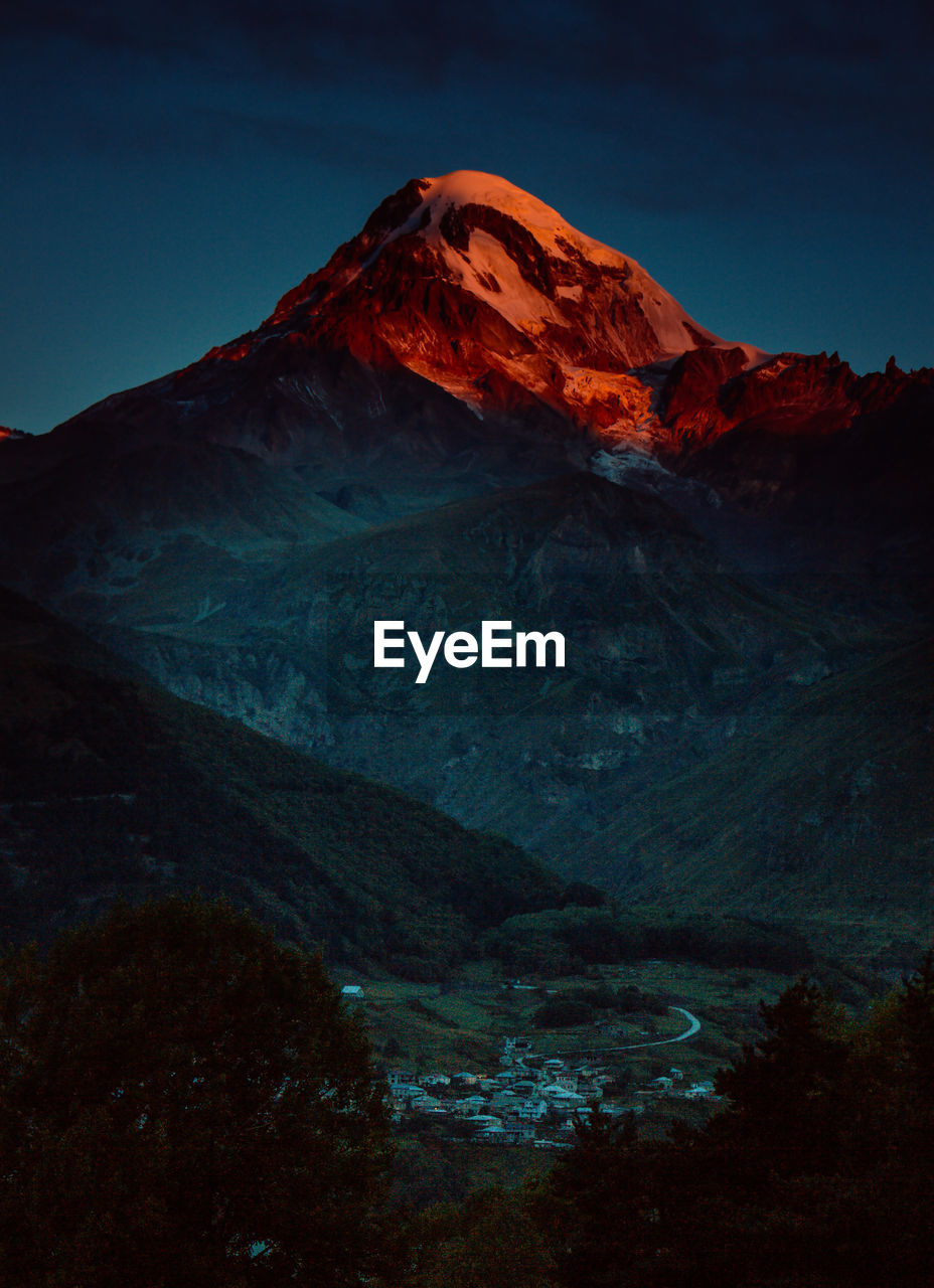 Scenic view of snowcapped mountains against sky at night