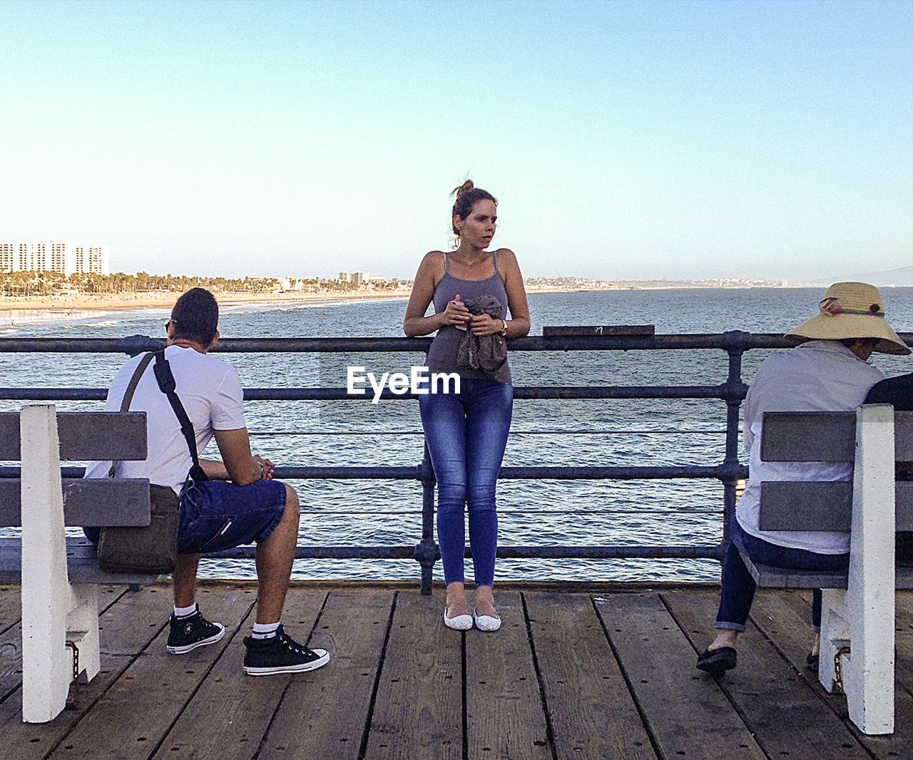 FULL LENGTH OF WOMAN STANDING ON RAILING