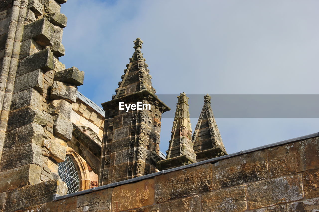 Low angle view of historic building against cloudy sky