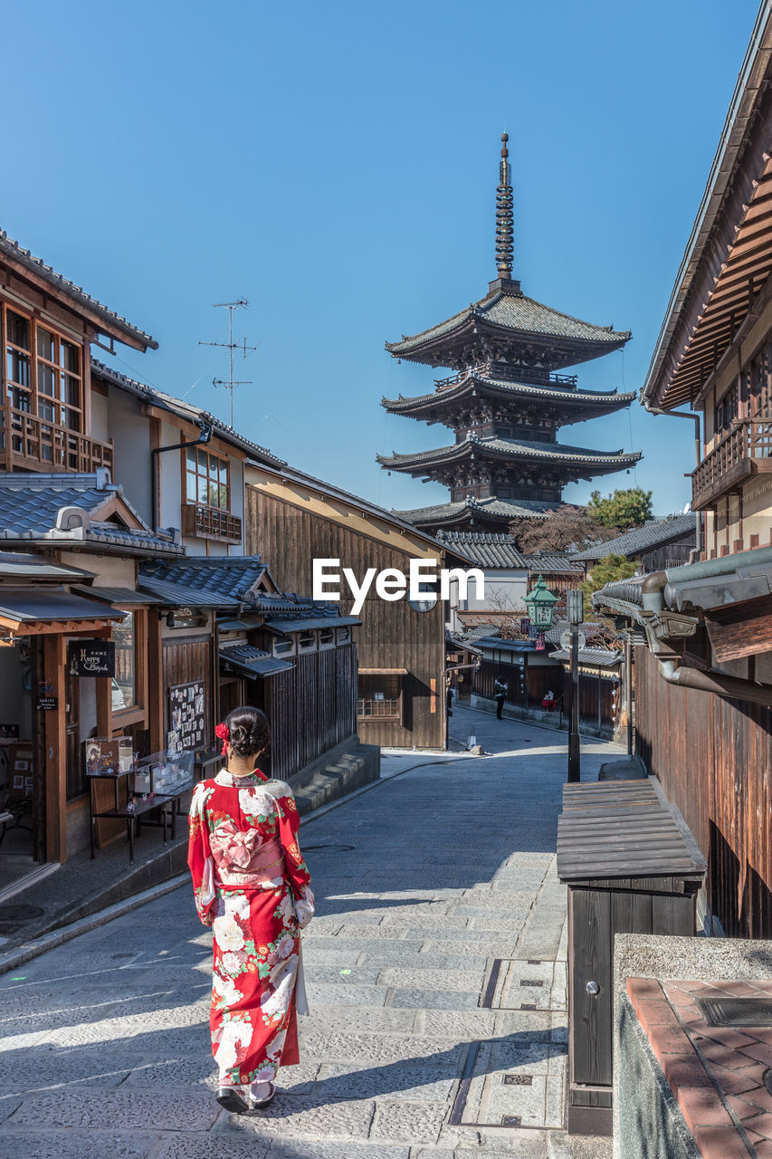 PEOPLE STANDING OUTSIDE TEMPLE AGAINST BUILDINGS