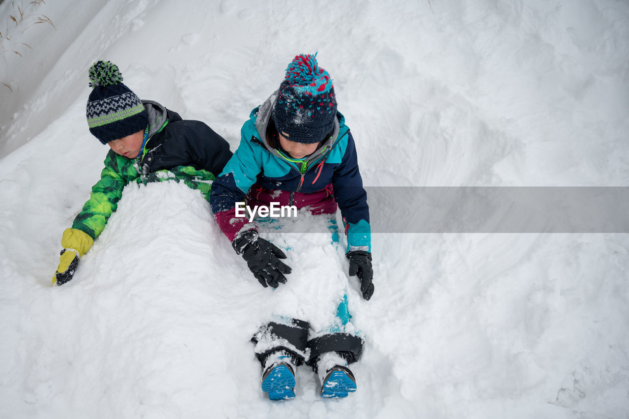 HIGH ANGLE VIEW OF MAN SKIING ON SNOWCAPPED MOUNTAINS