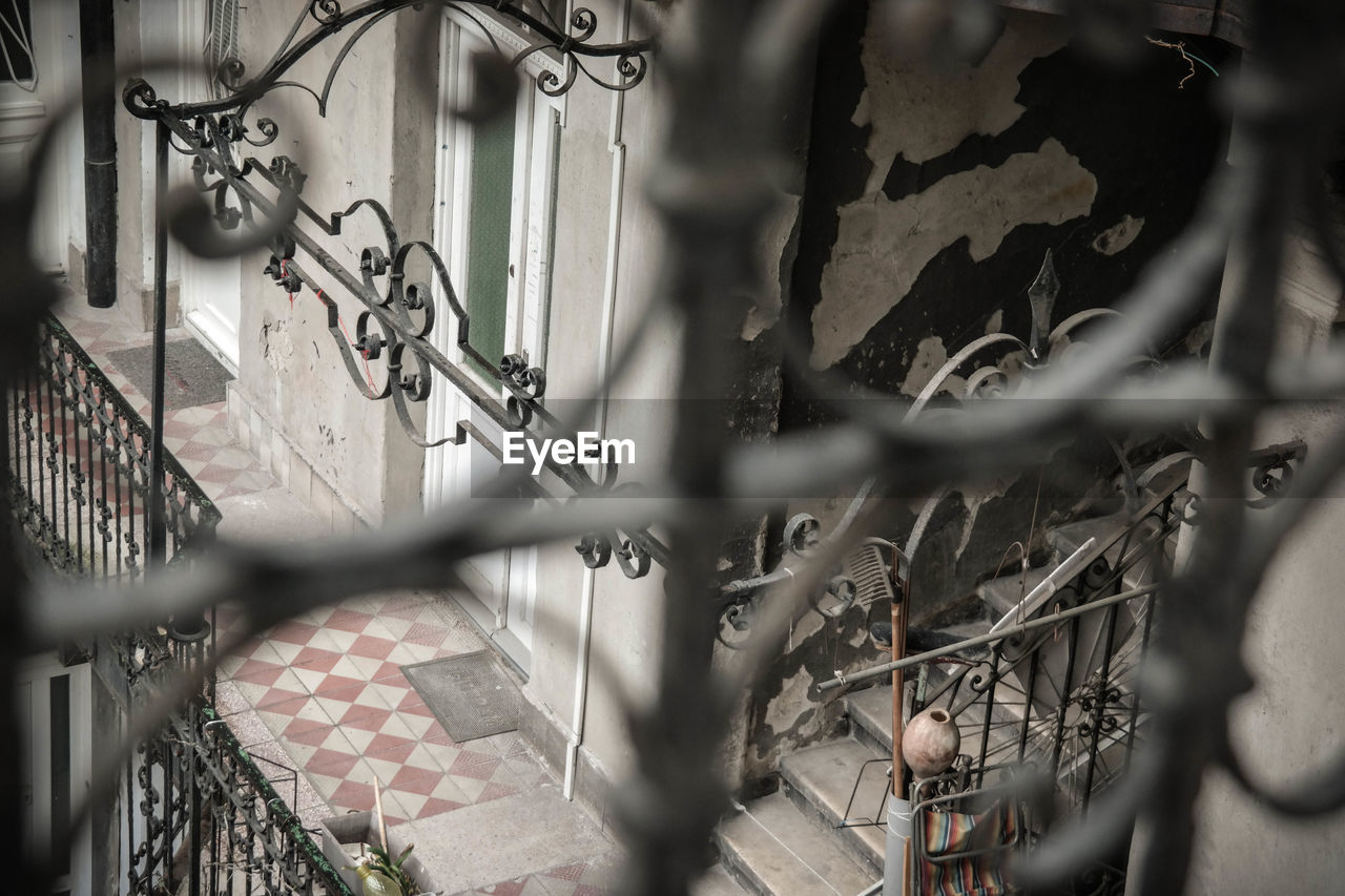 CLOSE-UP OF CHAINLINK FENCE AGAINST WALL