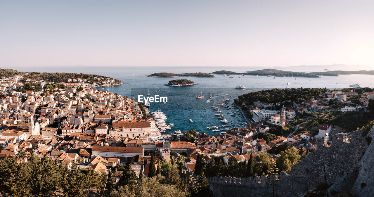 High angle view of town by sea against sky