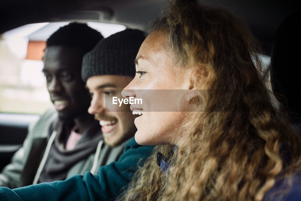 Friends looking away while enjoying in car