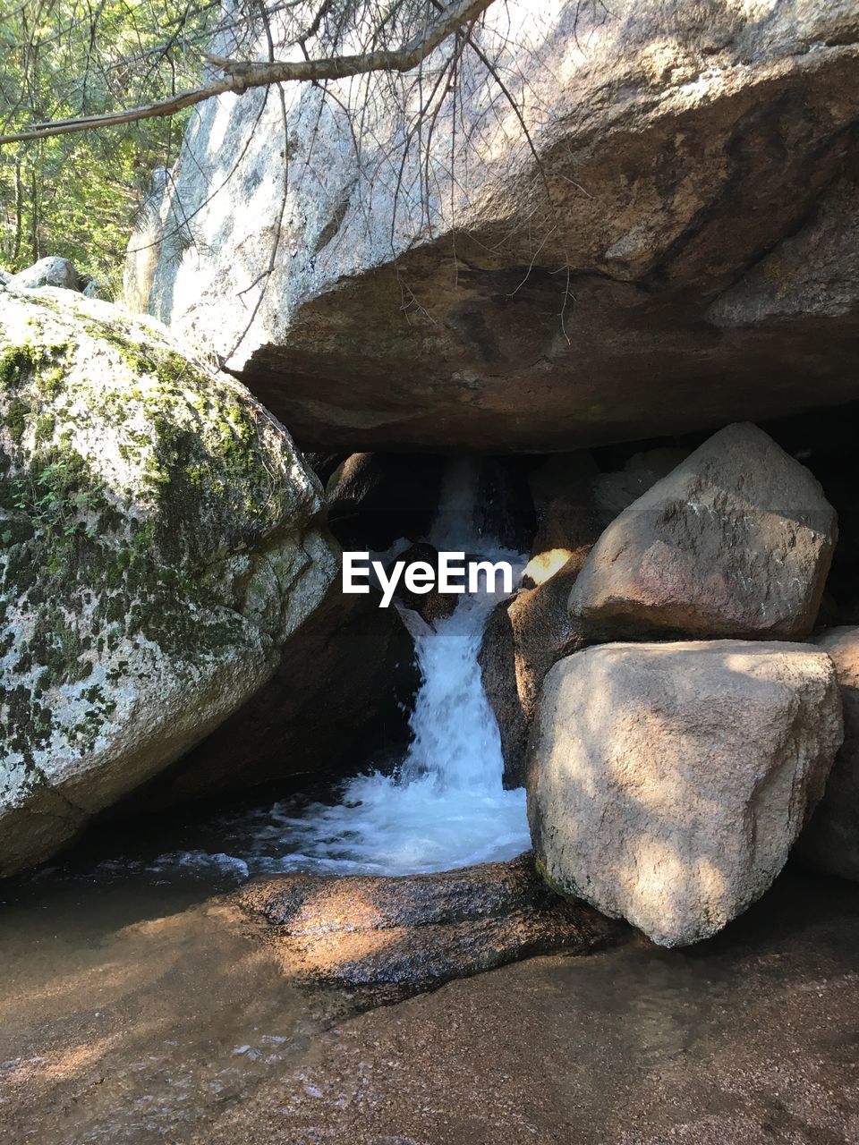 ROCKS IN WATER AGAINST ROCK FORMATION