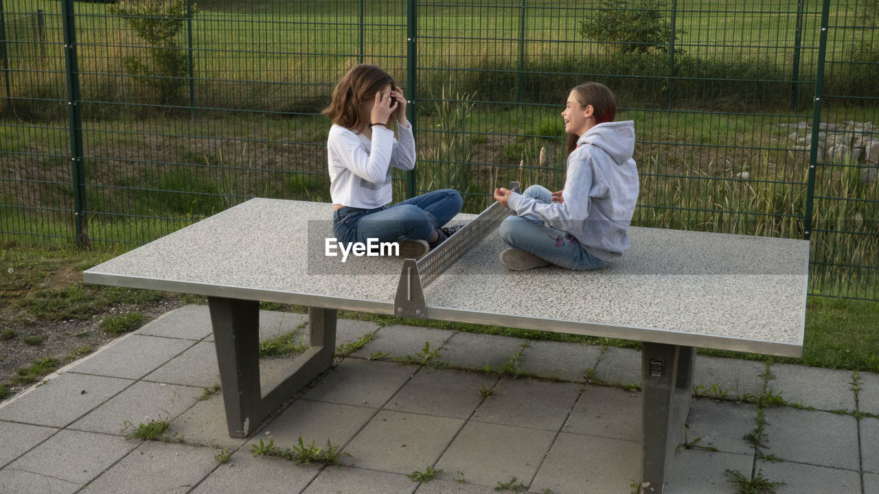 COUPLE SITTING ON BENCH IN PARK