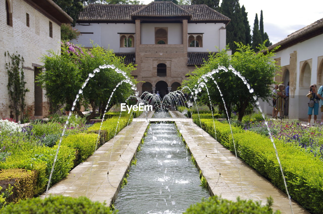 FOUNTAIN IN GARDEN AGAINST BUILDINGS