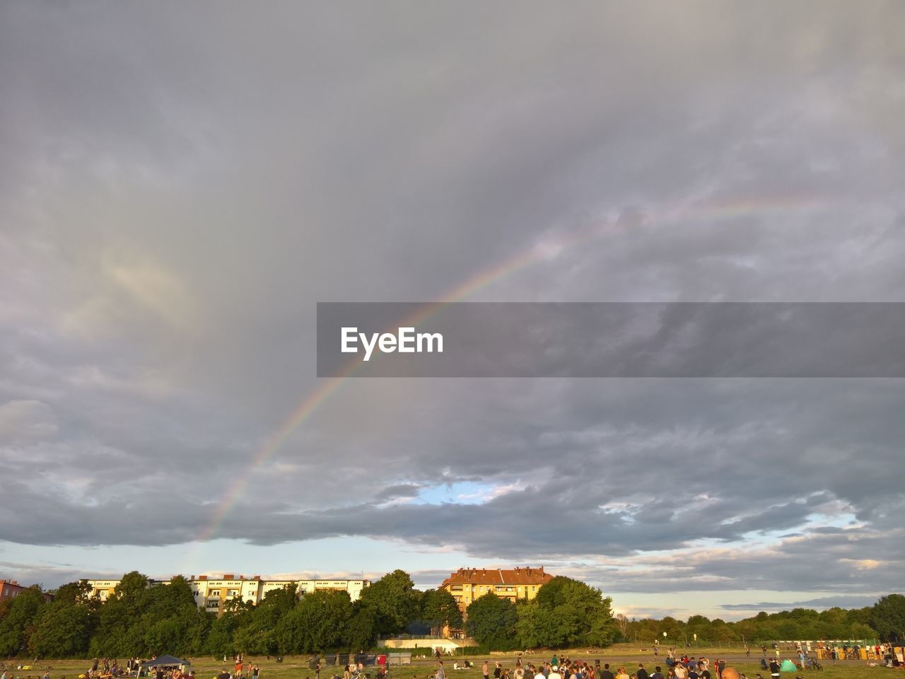 Rainbow over landscape against cloudy sky