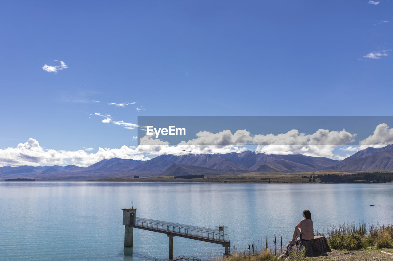 Rear view of people on lake against sky