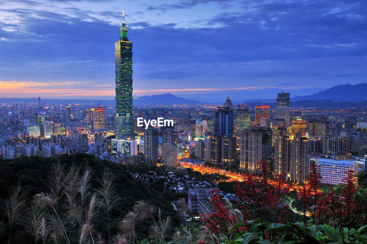 Illuminated cityscape against sky at night