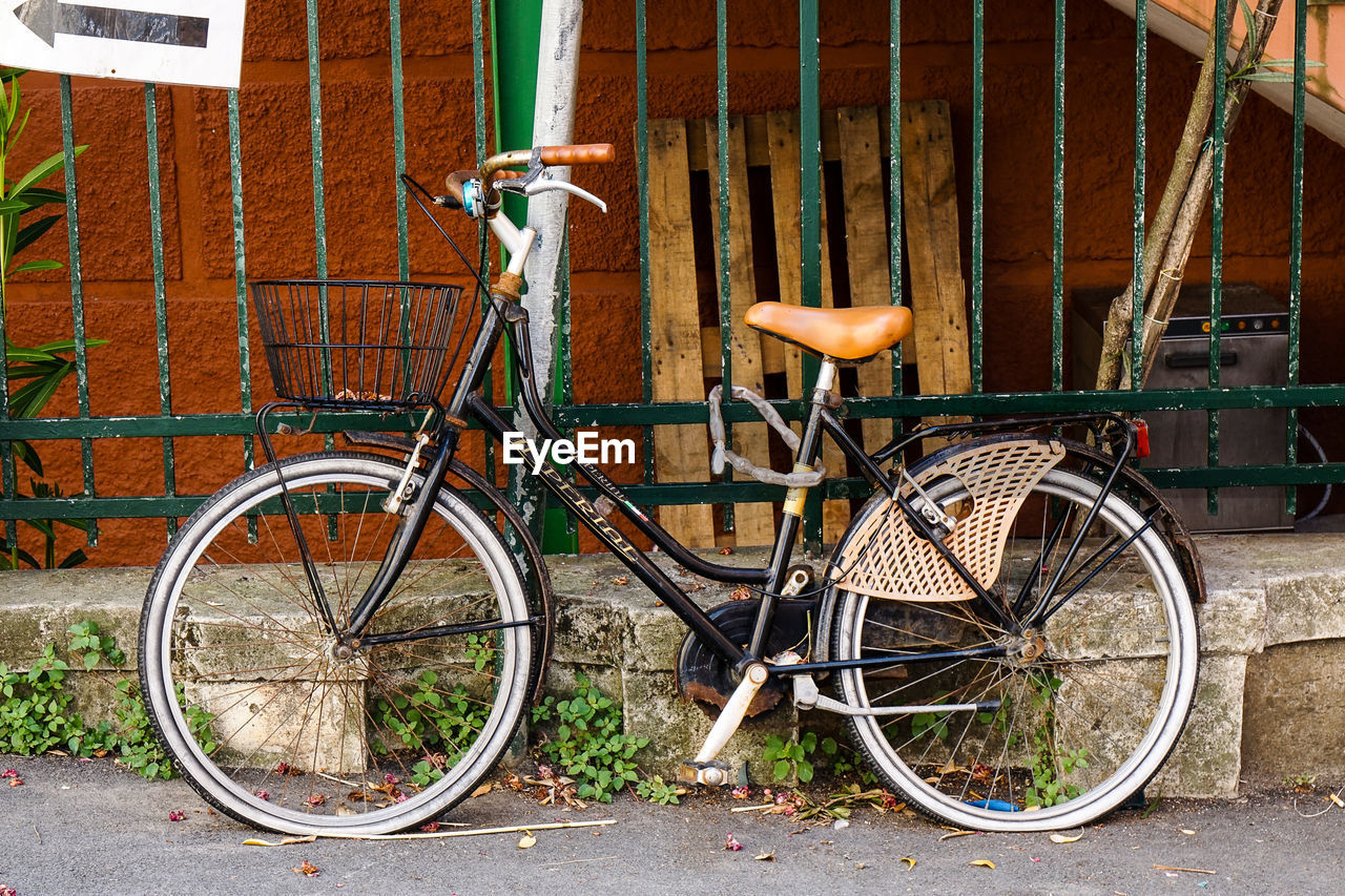 BICYCLE PARKED IN BASKET ON COBBLESTONE