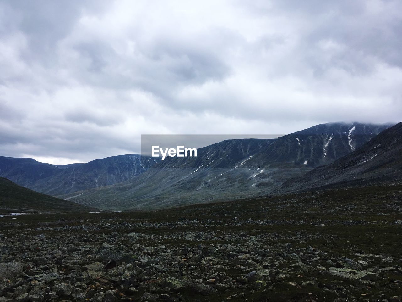 Scenic view of mountains against cloudy sky