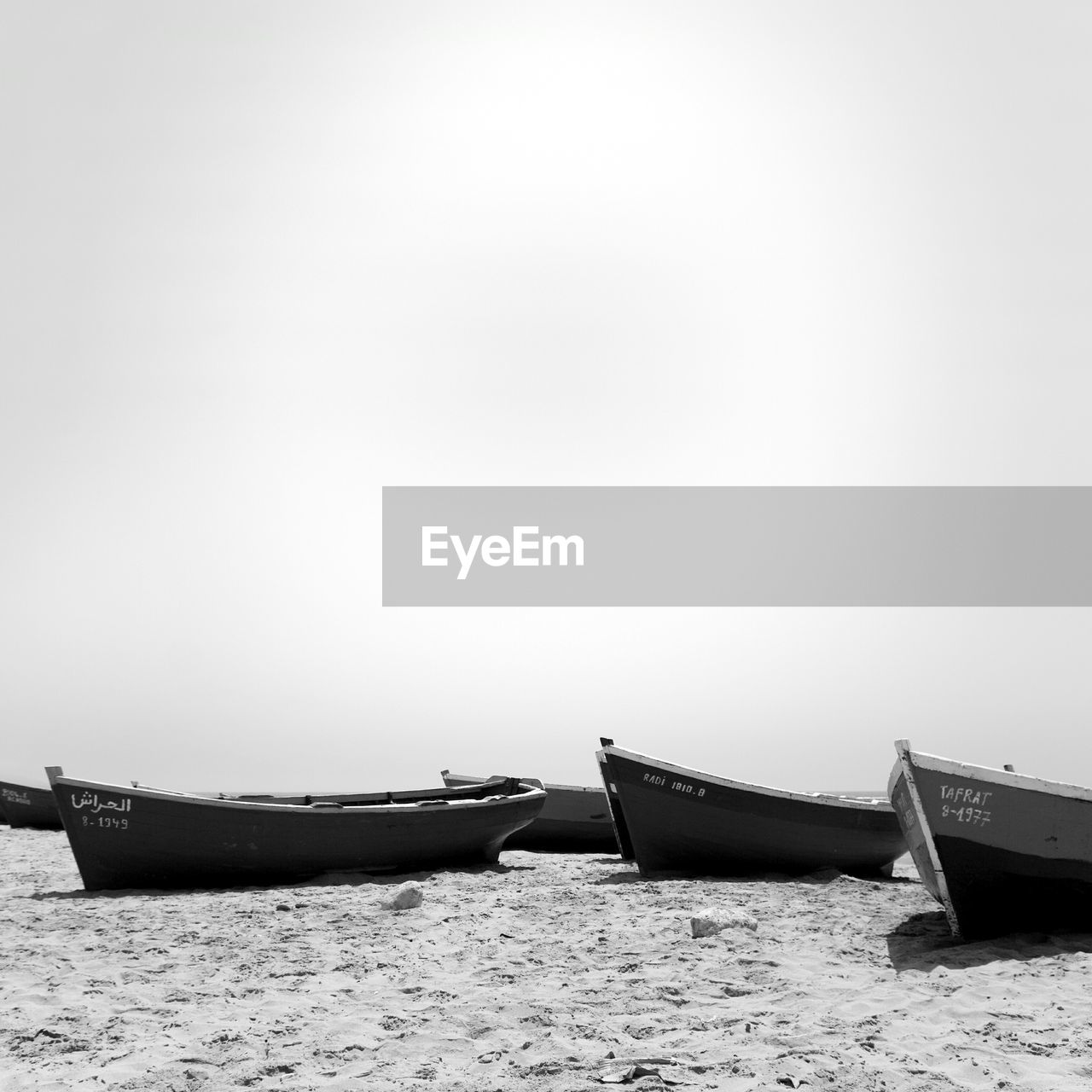 Boats at beach against clear sky