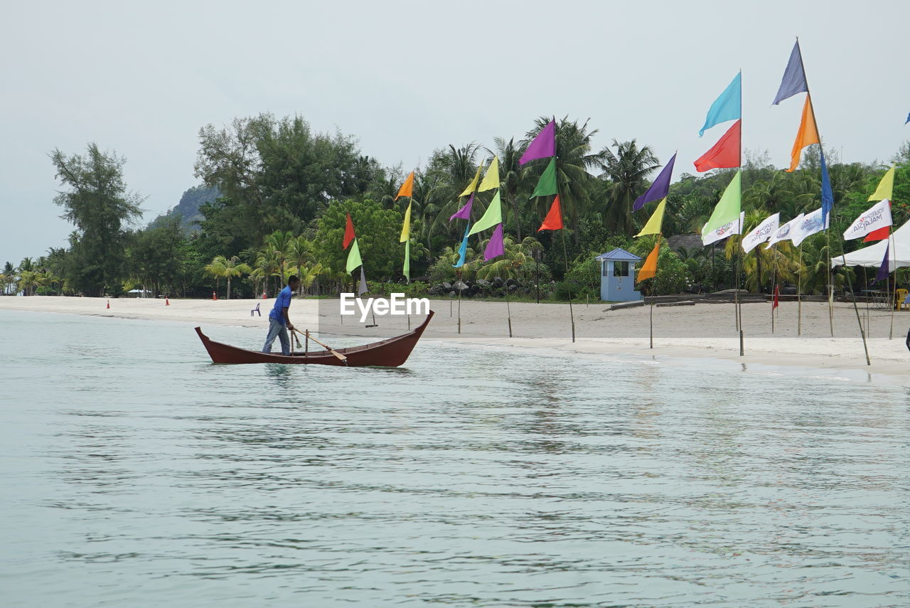 PEOPLE IN BOAT AGAINST SEA