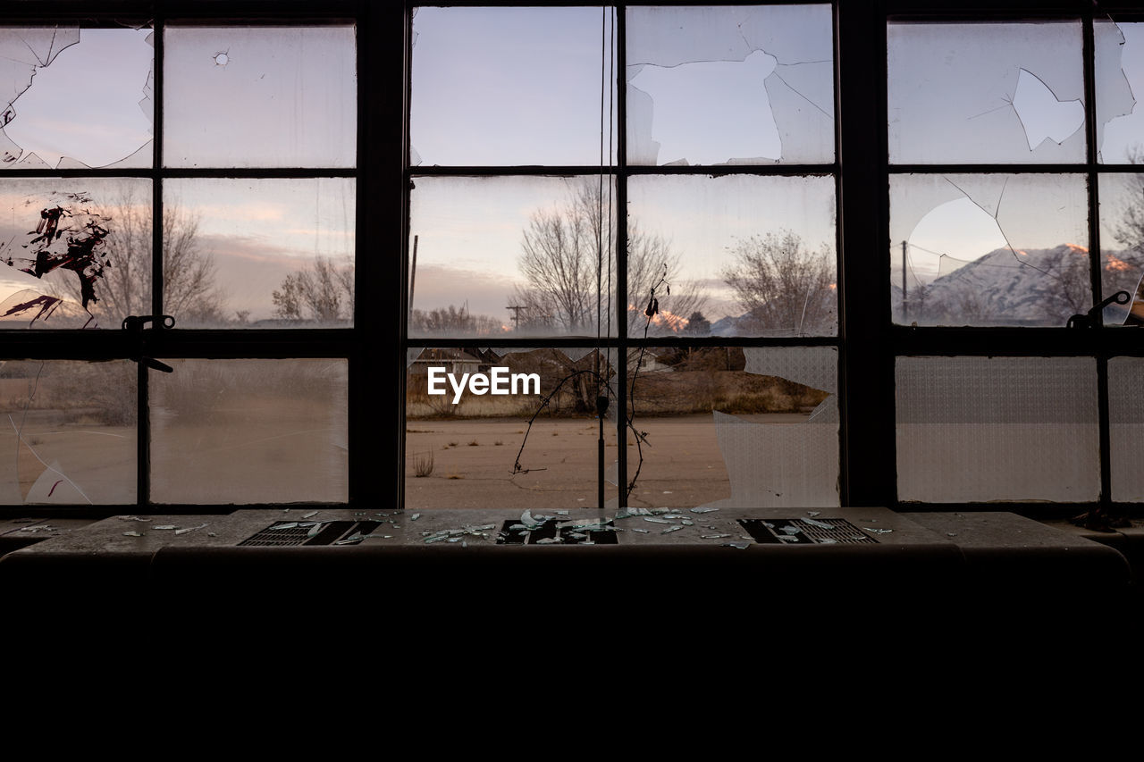 View of trees seen through broken window