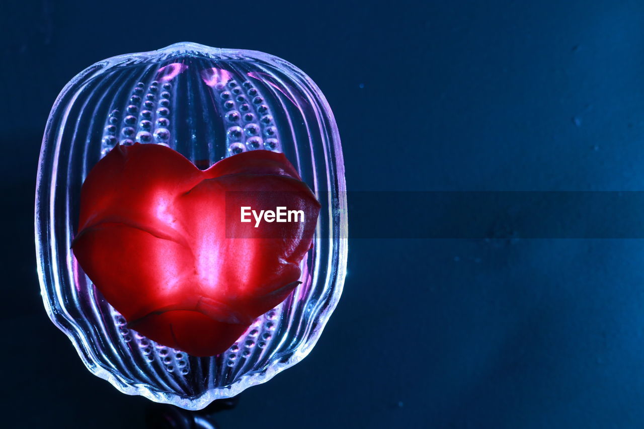 CLOSE-UP OF RED HEART SHAPE AGAINST BLUE BACKGROUND