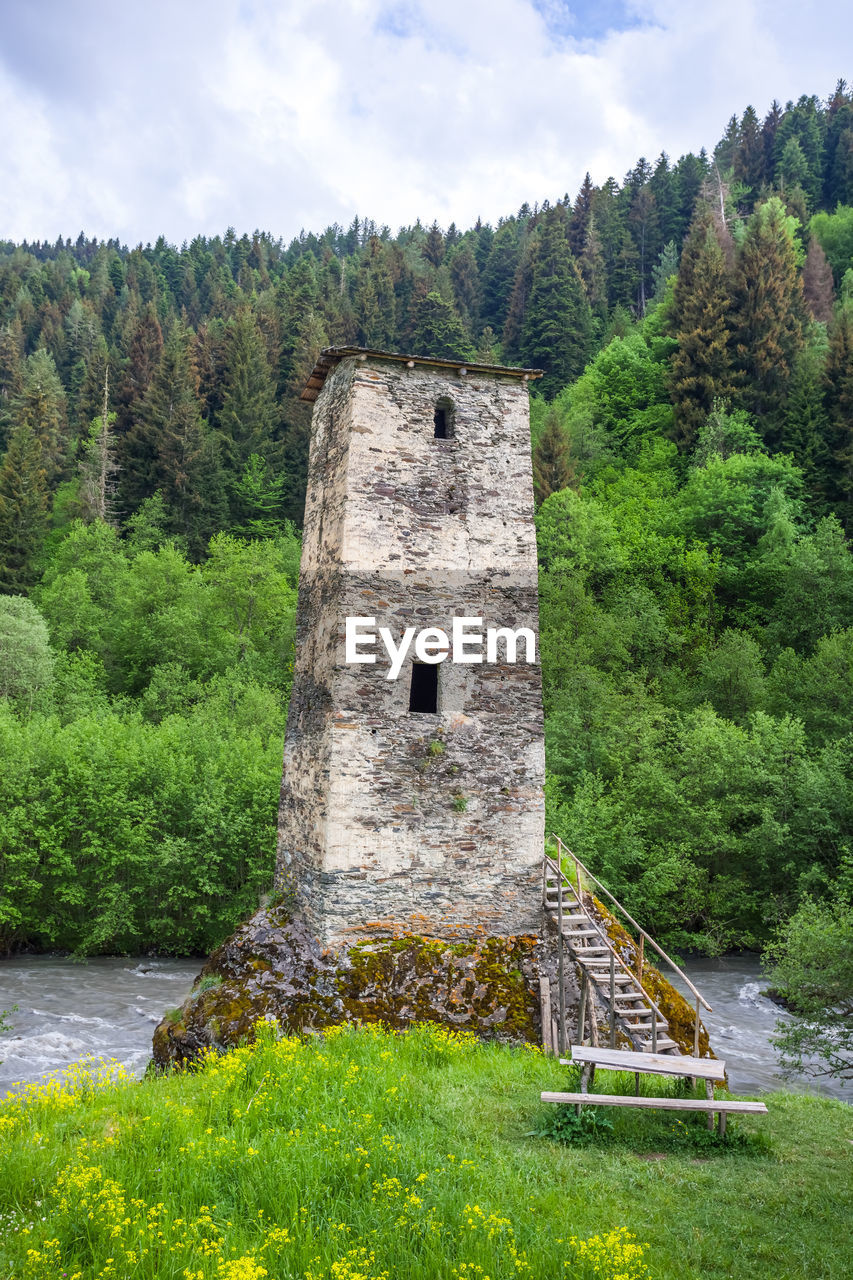 BUILT STRUCTURE ON FIELD AGAINST TREES