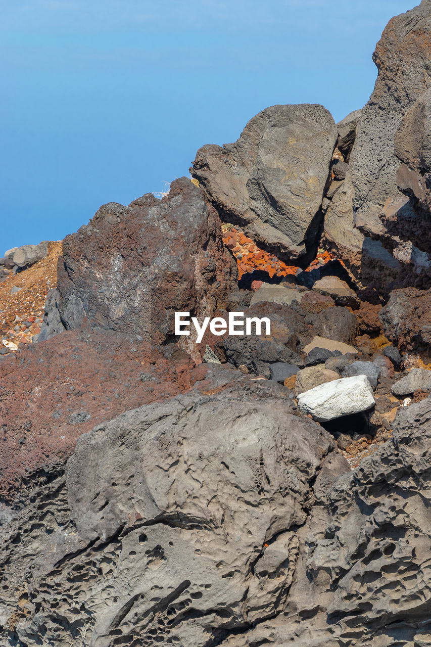 Rock formations on land against clear blue sky