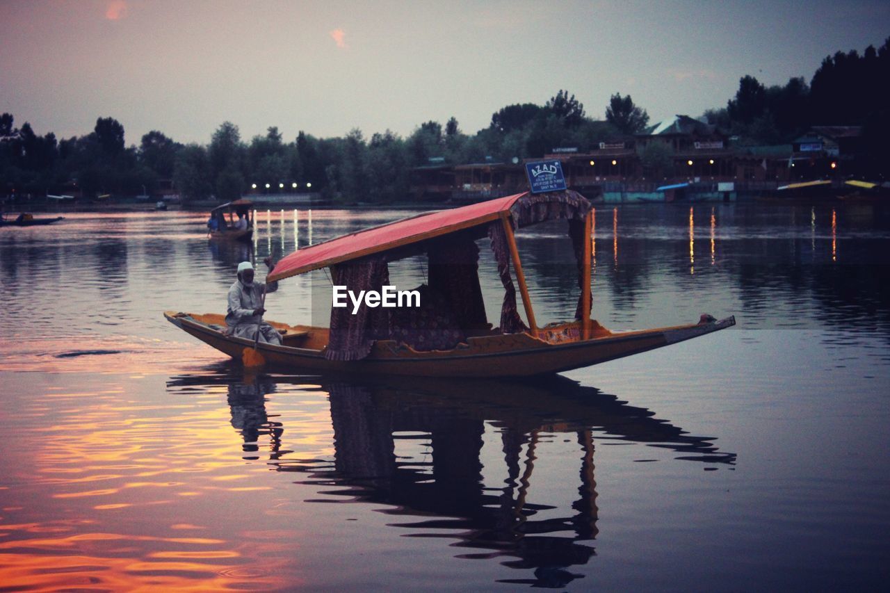 BOAT MOORED AT LAKE AGAINST SKY