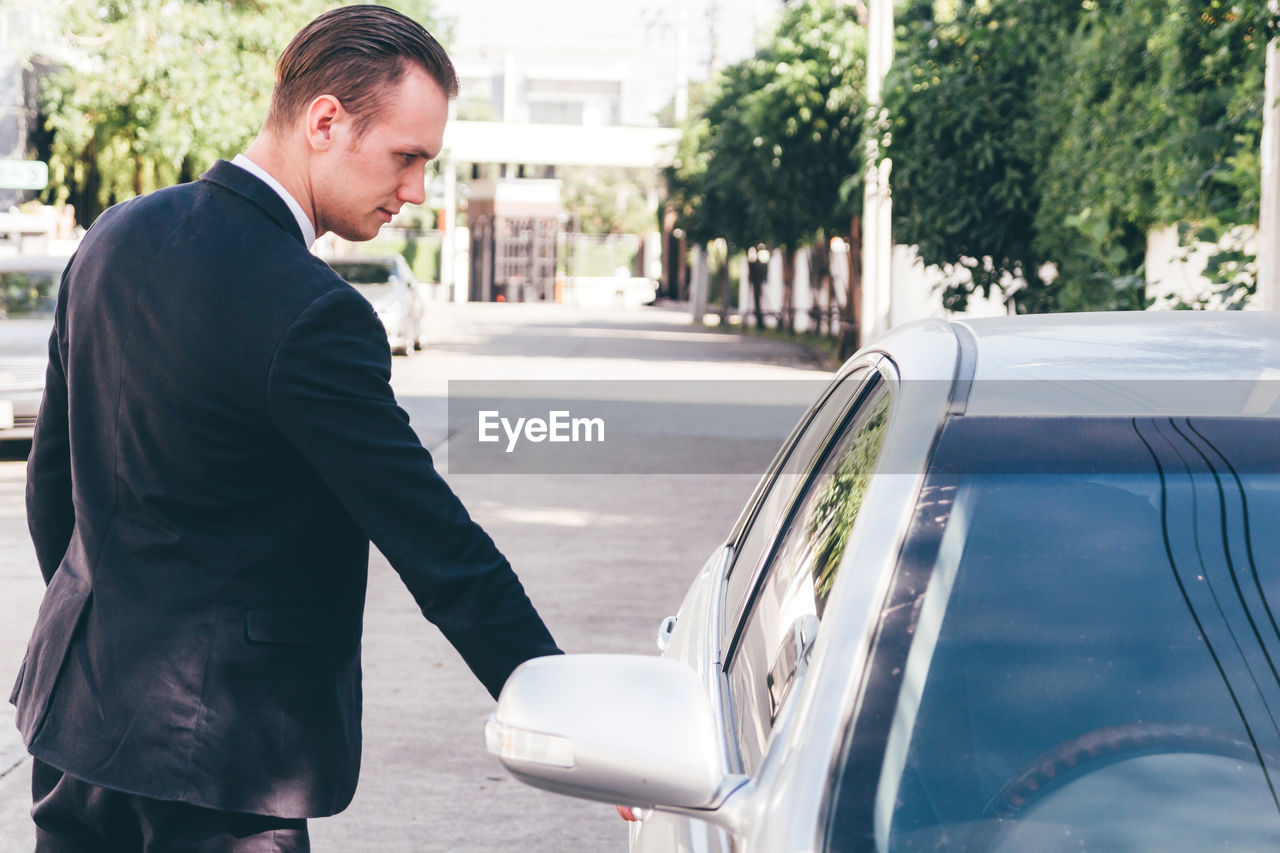 Businessman opening car door