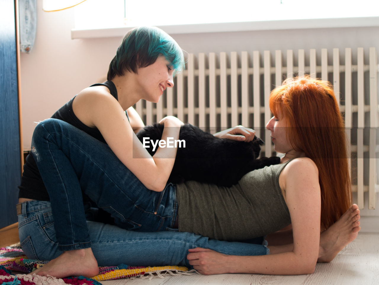 Lesbian couple with dog resting at home