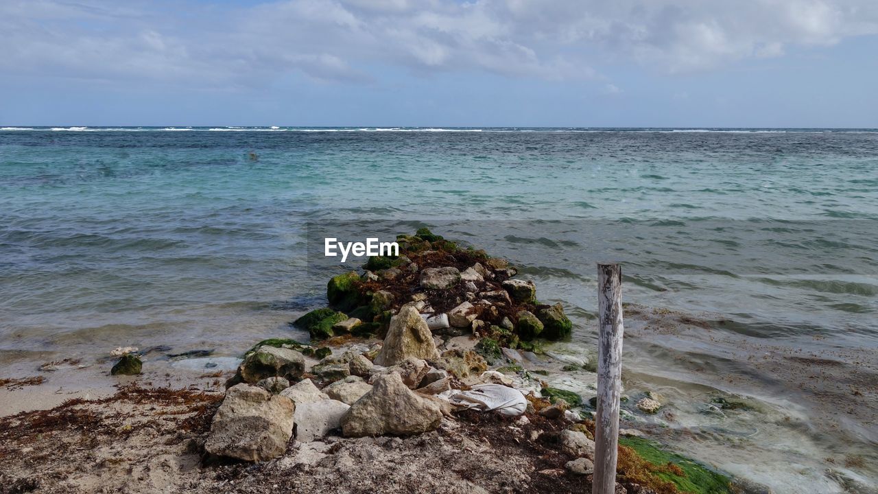 SCENIC VIEW OF ROCKS ON BEACH AGAINST SKY