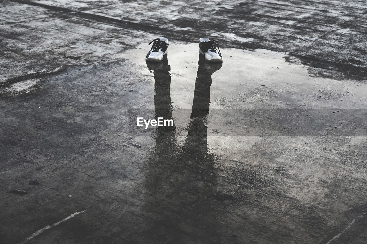 HIGH ANGLE VIEW OF WOMAN STANDING ON WATER