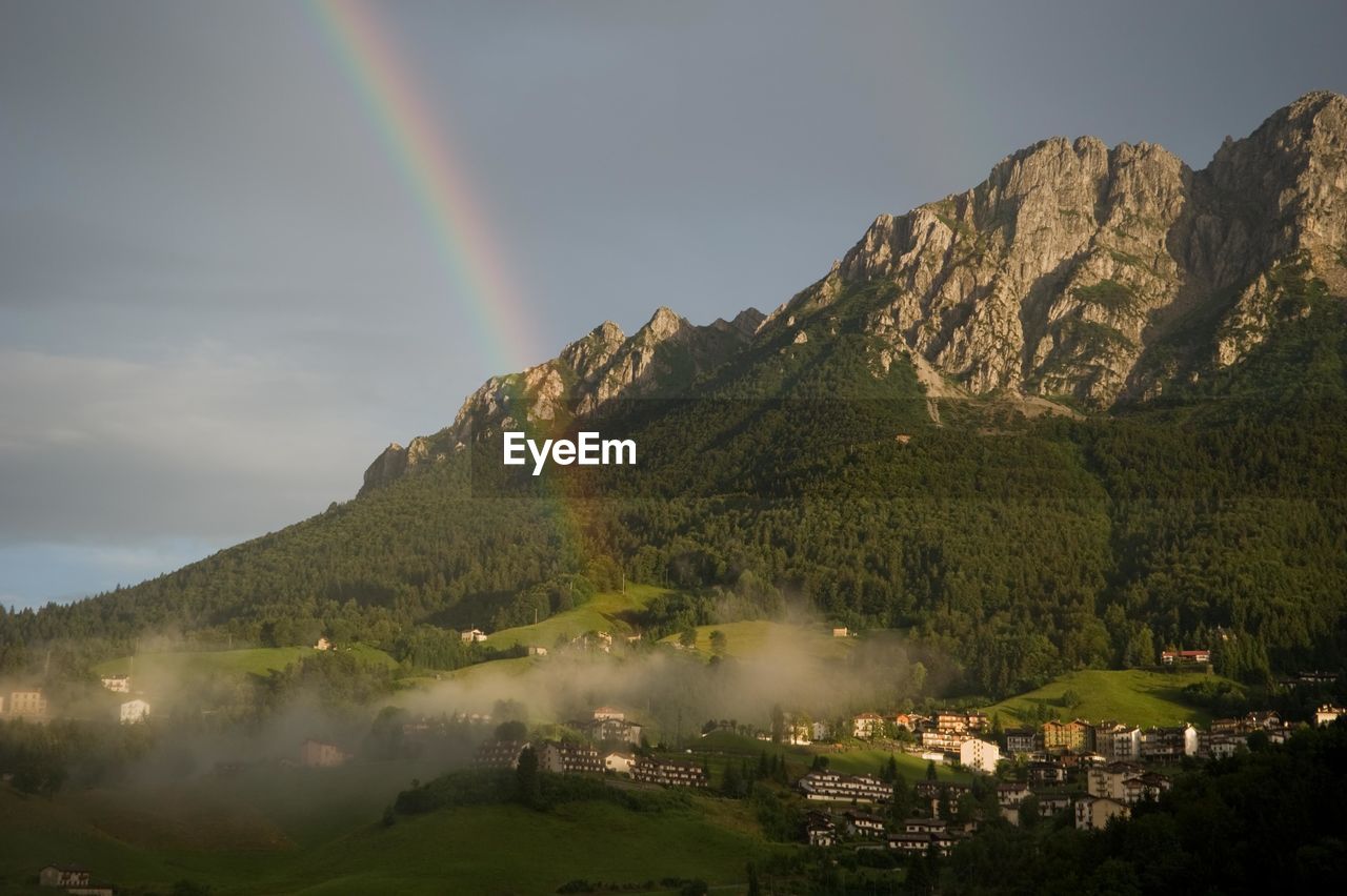 Scenic view of rainbow over mountain against sky