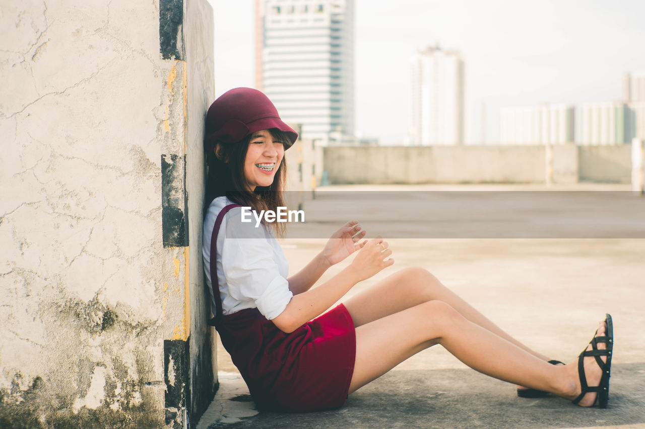 FULL LENGTH OF WOMAN SITTING IN HAT