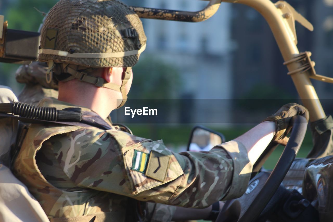 Side view of army soldier sitting in vehicle