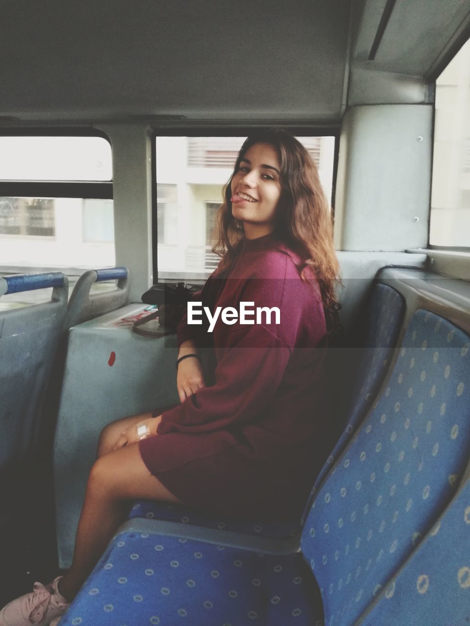 Portrait of smiling woman sitting in bus