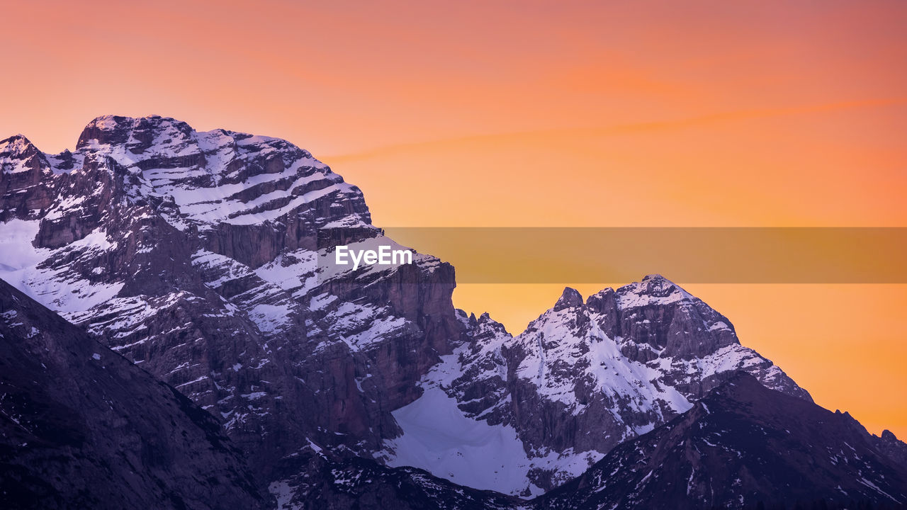 Scenic view of snowcapped mountains against sky during sunset