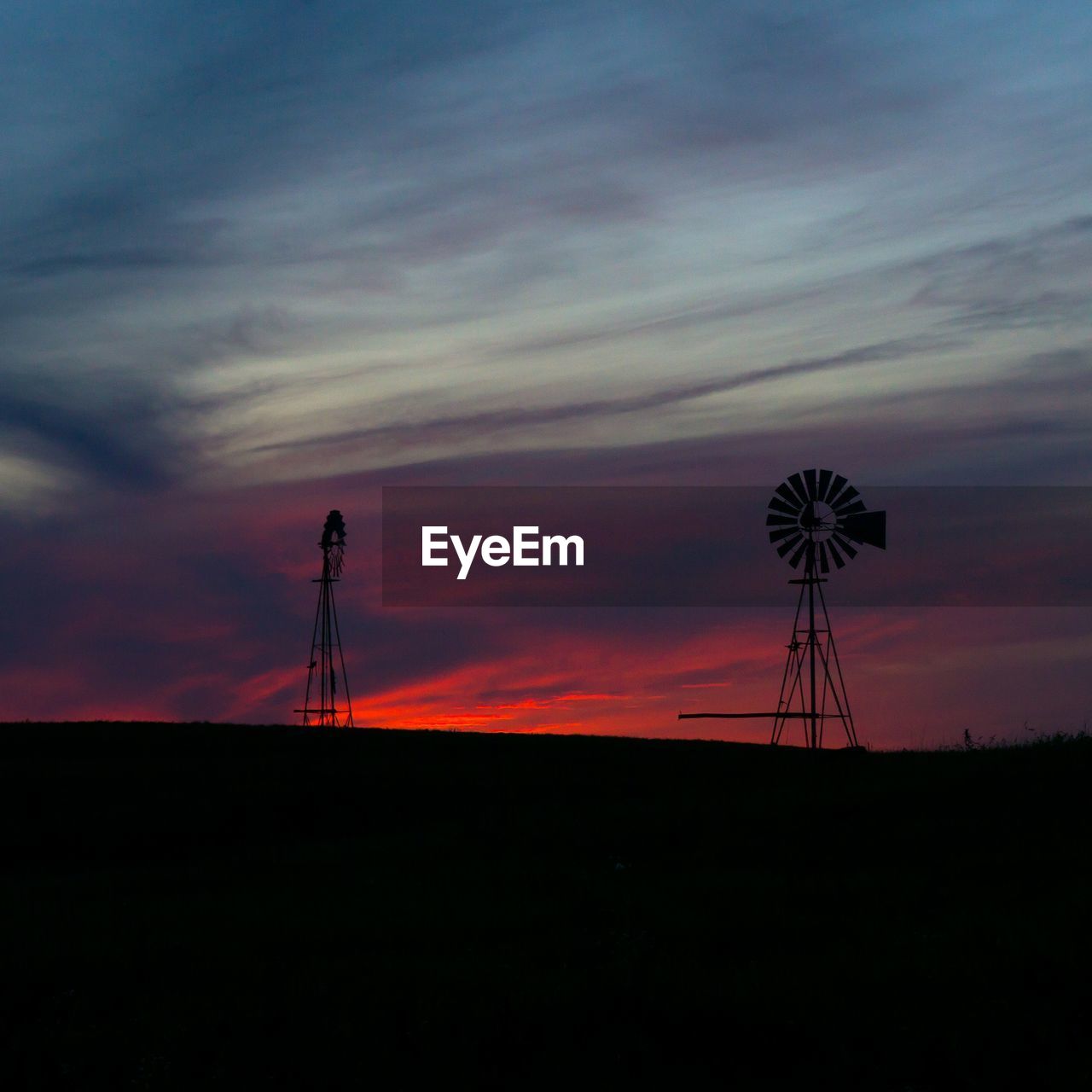 LOW ANGLE VIEW OF SILHOUETTE WINDMILL AGAINST SKY AT SUNSET