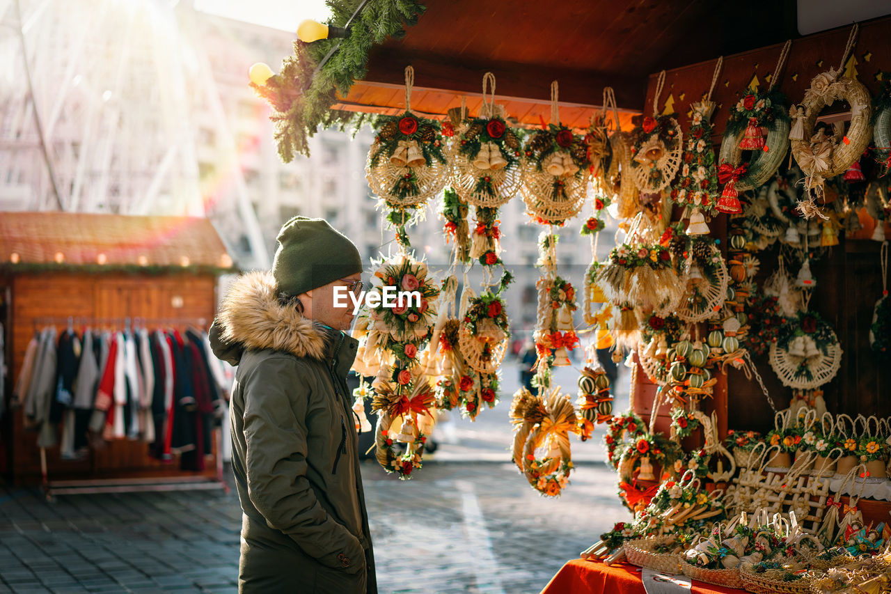 Man in warm clothing looking at christmas stall