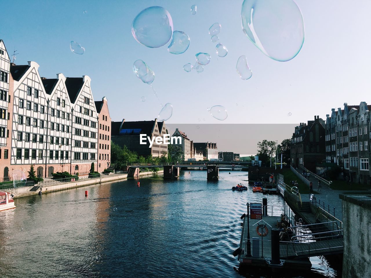Bubbles over river against clear sky in city