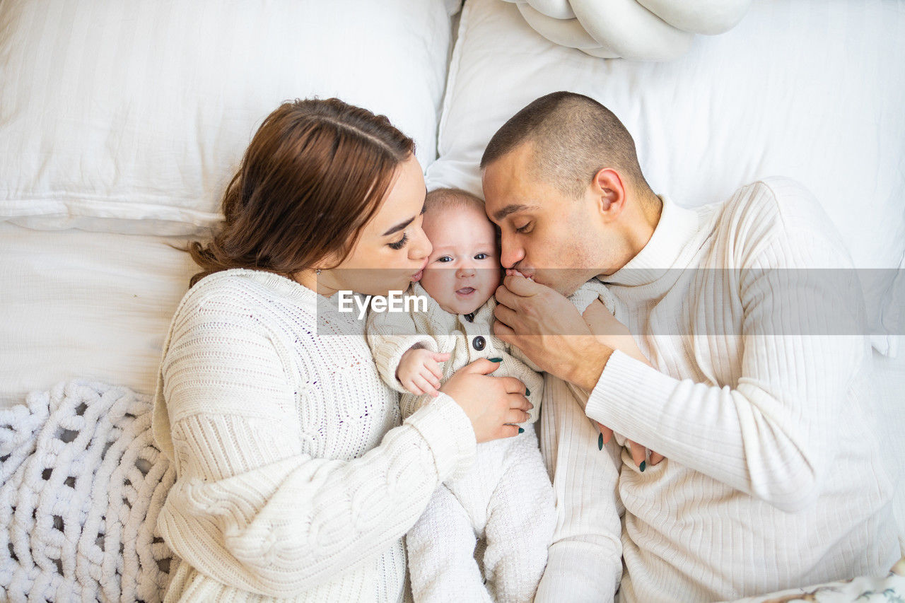High angle view of family with newborn child on bed