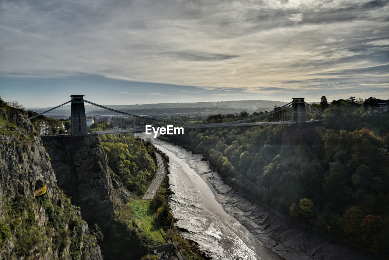 View of bridge over mountain against cloudy sky