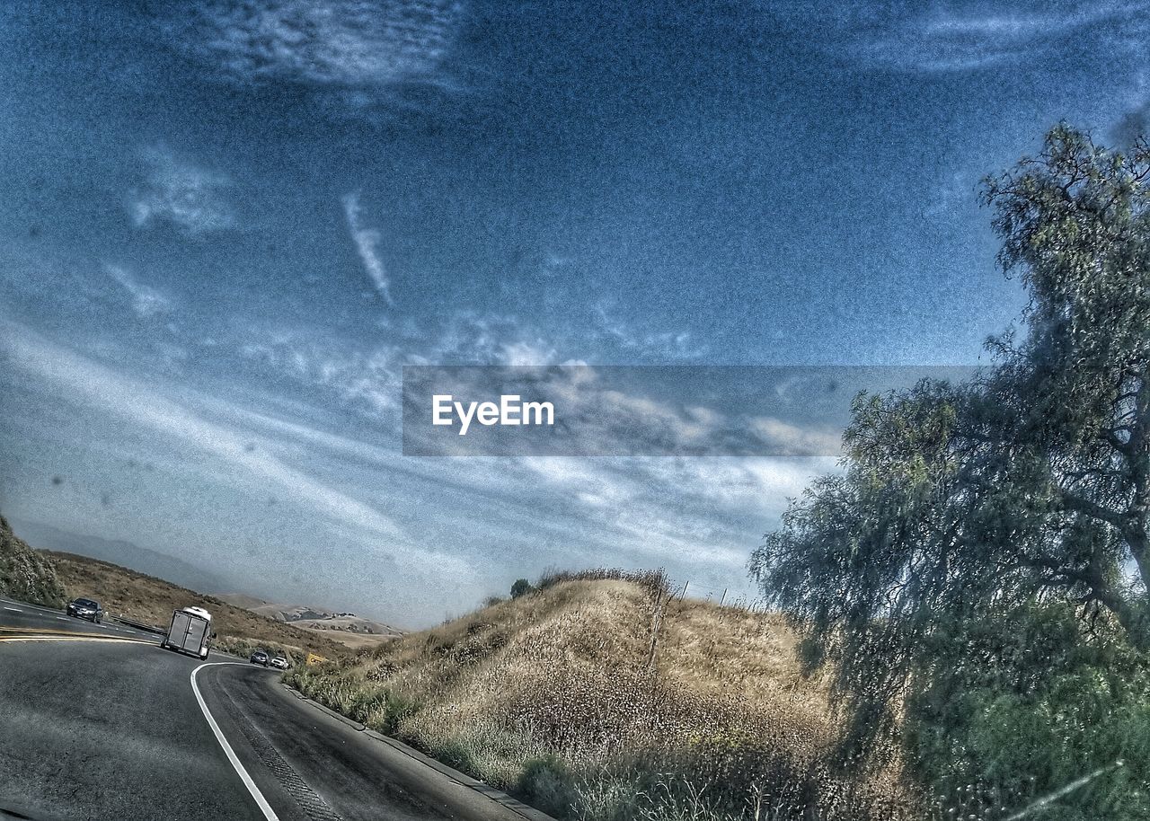 VIEW OF ROAD AGAINST CLOUDY SKY