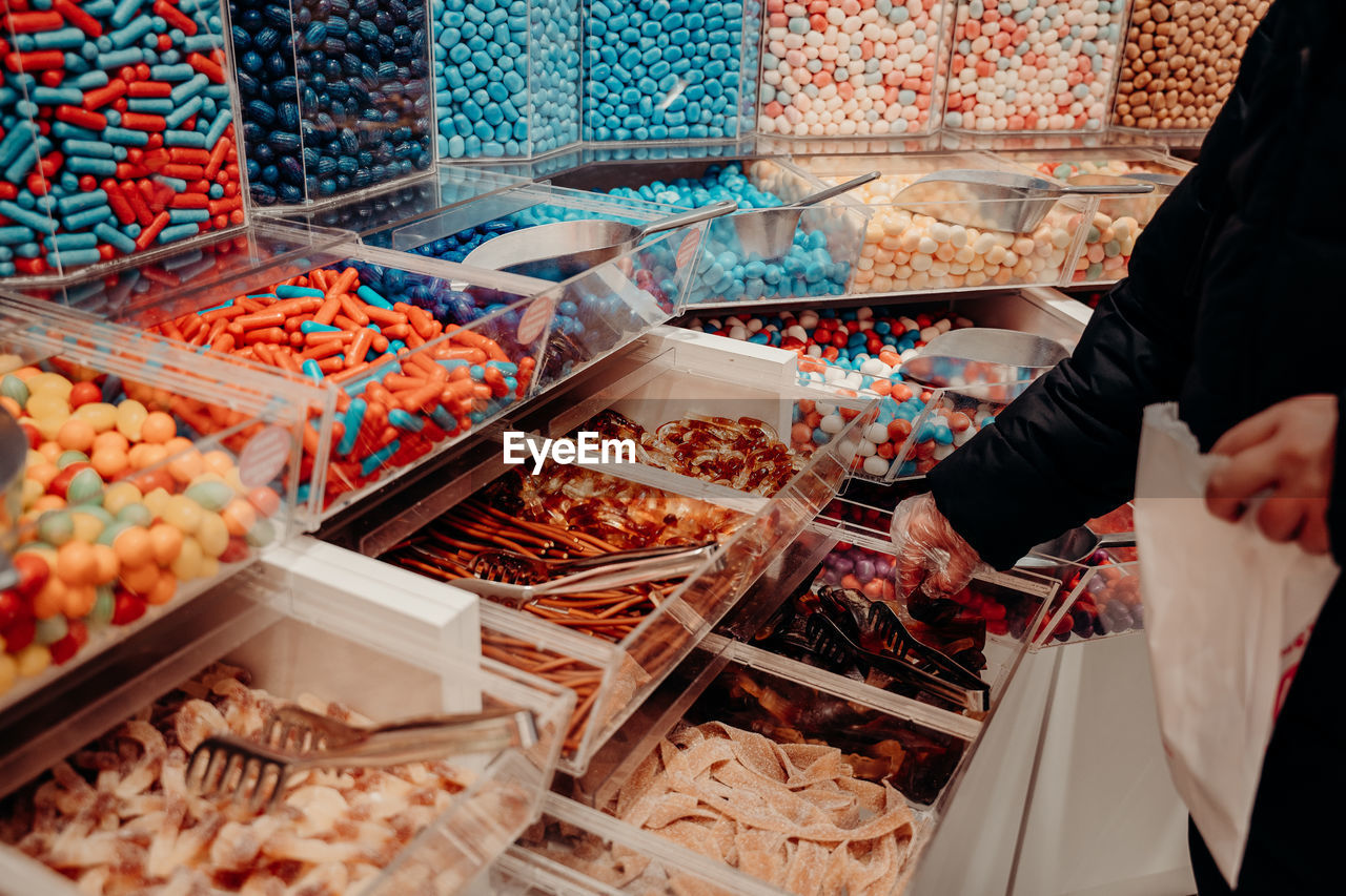 midsection of man holding food for sale at market stall