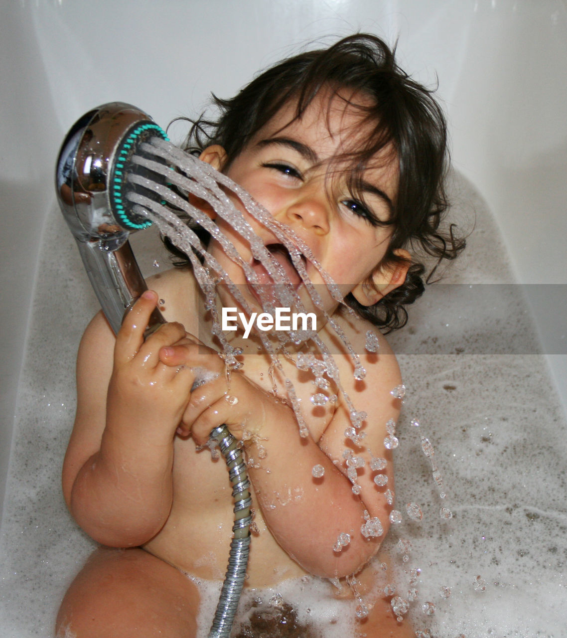 Portrait of girl enjoying bath in tub
