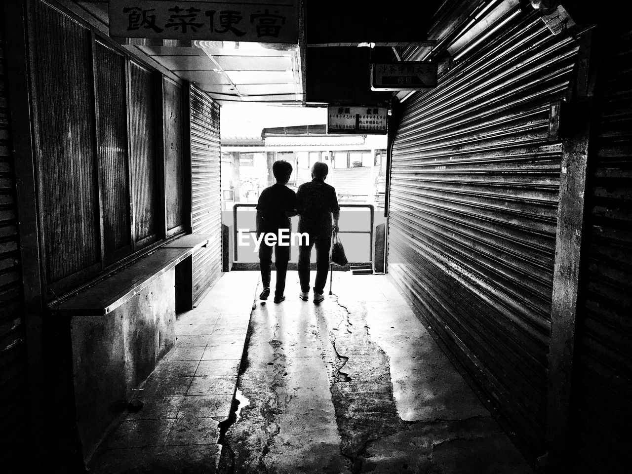 REAR VIEW OF SILHOUETTE PEOPLE WALKING IN BUILDING