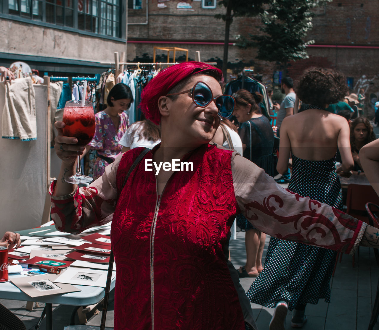 Smiling woman holding drink at market