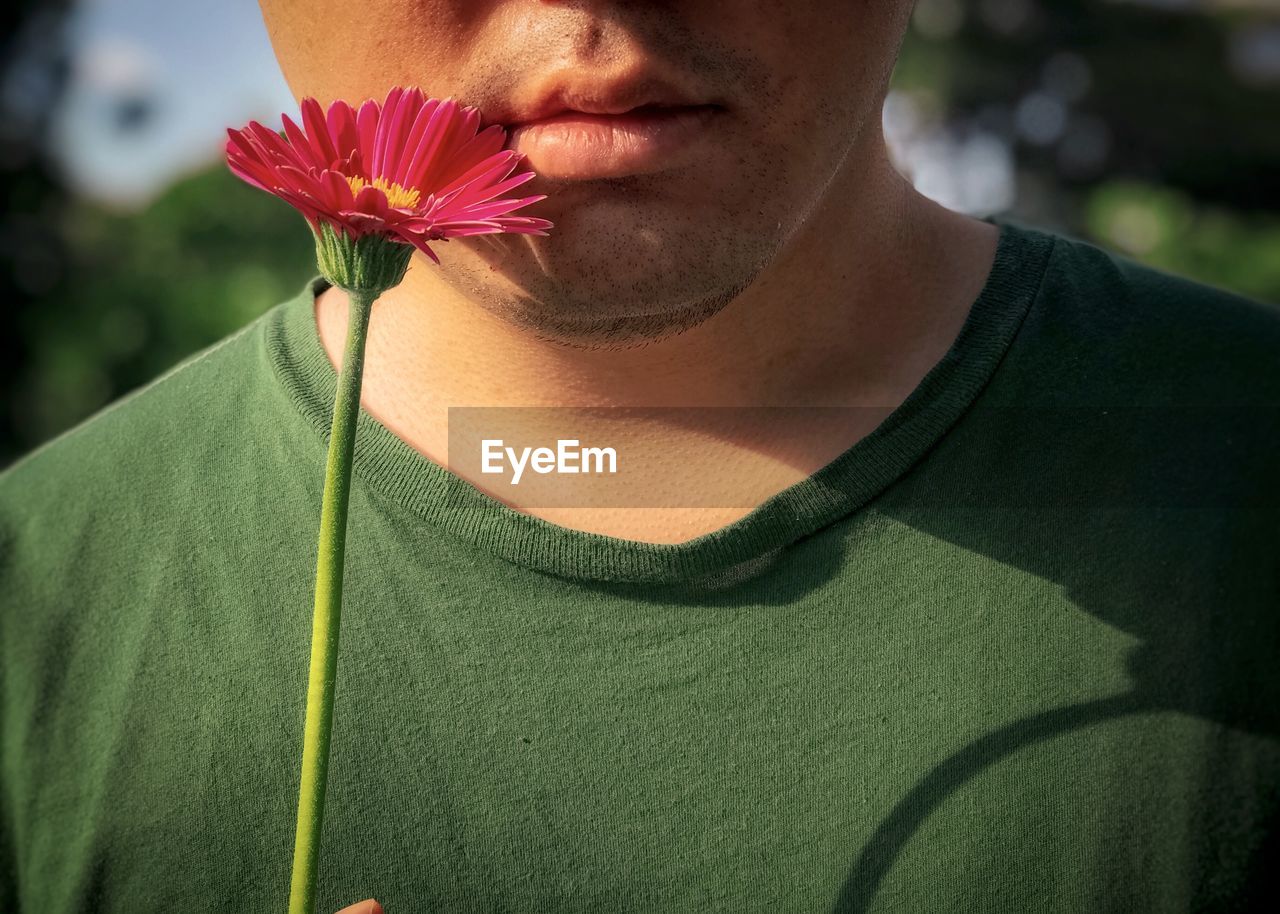 CLOSE-UP OF BEAUTIFUL WOMAN WITH PINK FLOWER