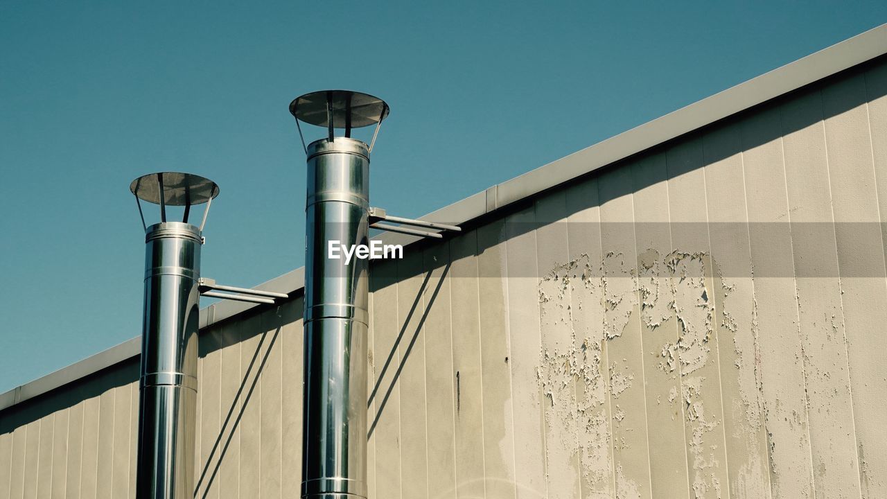 Low angle view of pipes against clear sky