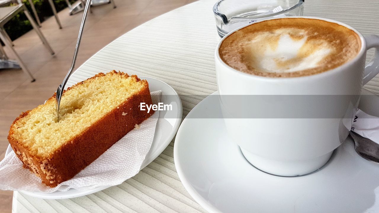 CLOSE-UP OF COFFEE CUP AND CAKE