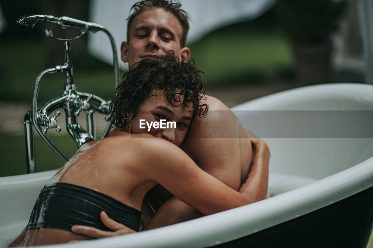 Couple in bathtub outdoors