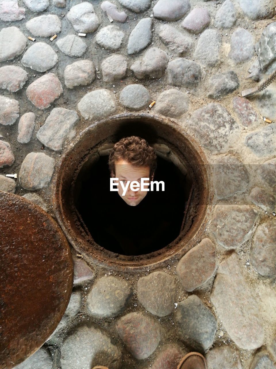 Full length of man standing in manhole