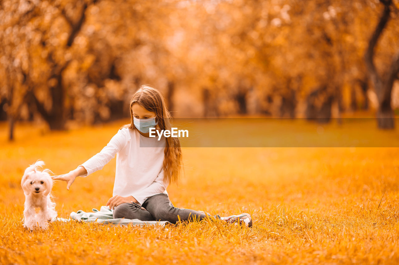 MAN PLAYING WITH DOG ON AUTUMN LEAF