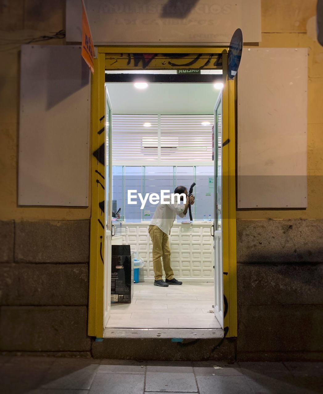 REAR VIEW OF MAN LOOKING AT ENTRANCE OF DOOR