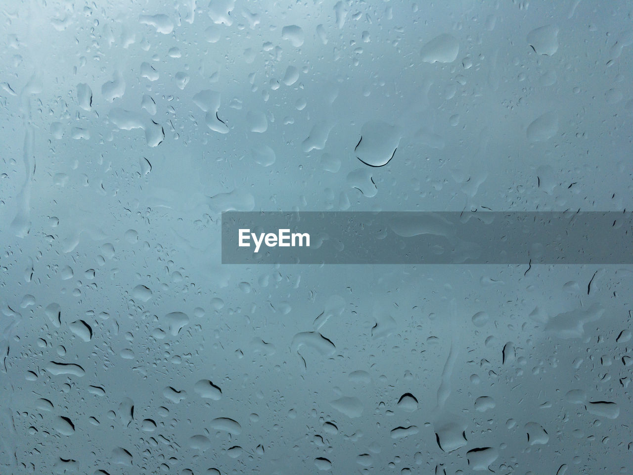 FULL FRAME SHOT OF WET GLASS WINDOW IN RAINY SEASON